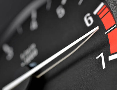 Tachometer or rev counter red lining. Close up focus on the needle tip.